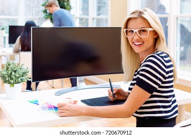 Graphic designer using her pen tablet in a bright office