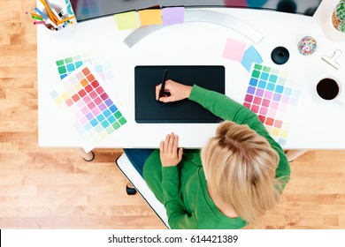 Graphic designer using her graphic tablet in an office