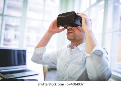 Graphic designer using virtual reality headset in office - Powered by Shutterstock