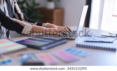 Graphic designer women typing data on laptop while working about graphic designing with technology.