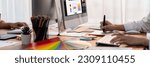 Graphic designer work on computer laptop and with graphic drawing pen while brainstorming unique design with professional graphic team in modern digital studio workplace. Panorama shot. Scrutinize