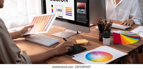 Graphic designer work on computer laptop and with graphic drawing pen while brainstorming unique design with professional graphic team in modern digital studio workplace. Panorama shot. Scrutinize - Shutterstock ID 2291349107