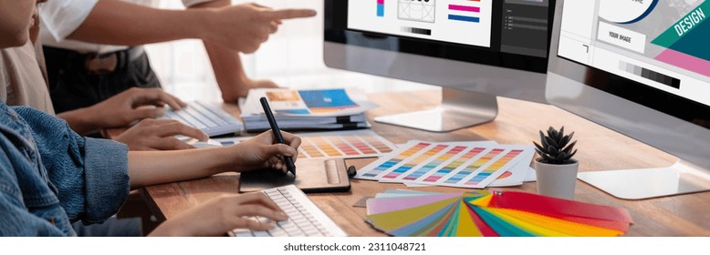 Graphic designer work on computer laptop and with graphic drawing pen while brainstorming unique design with professional graphic team in modern digital studio workplace. Panorama shot. Scrutinize - Shutterstock ID 2311048721