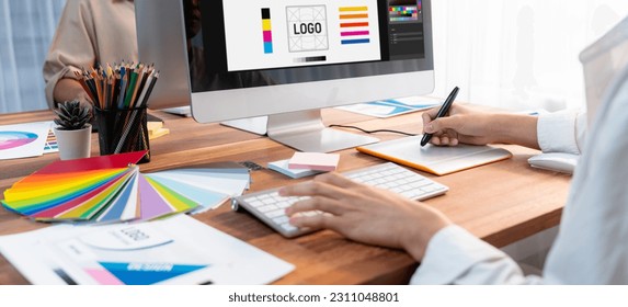 Graphic designer work on computer laptop and with graphic drawing pen while brainstorming unique design with professional graphic team in modern digital studio workplace. Panorama shot. Scrutinize - Powered by Shutterstock