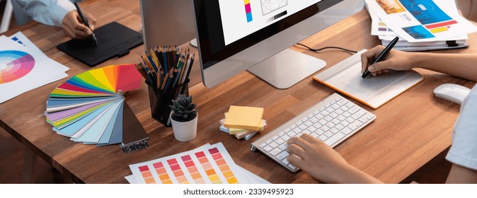 Graphic designer work on computer laptop and with graphic drawing pen while brainstorming unique design with professional graphic team in modern digital studio workplace. Panorama shot. Scrutinize - Powered by Shutterstock