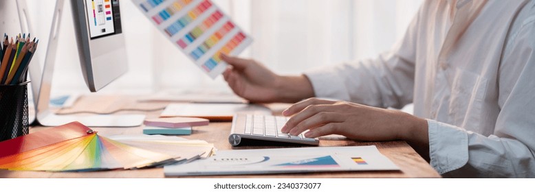 Graphic designer work on computer laptop and with graphic drawing pen while brainstorming unique design with professional graphic team in modern digital studio workplace. Panorama shot. Scrutinize - Shutterstock ID 2340373077