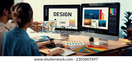 Graphic designer work on computer laptop and with graphic drawing pen while brainstorming unique design with professional graphic team in modern digital studio workplace. Panorama shot. Scrutinize