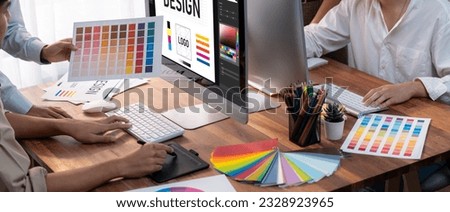 Graphic designer work on computer laptop and with graphic drawing pen while brainstorming unique design with professional graphic team in modern digital studio workplace. Panorama shot. Scrutinize