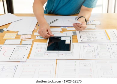 Graphic designers work together with UX UI designer planning application template layout framework for mobile phone computer mobile - Shutterstock ID 1902462175