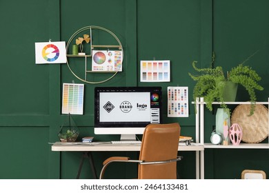 Graphic designer's workplace with computer monitor and color palettes in office - Powered by Shutterstock