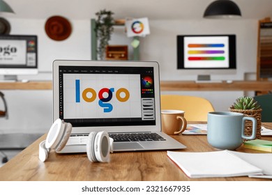 Graphic designer's workplace with laptop in office, closeup