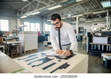 A Graphic Engineer Doing Calculations For Prints At Printing Shop.