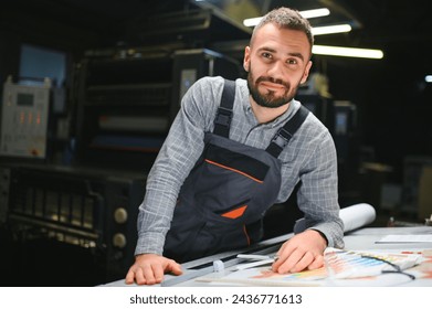 Graphic engineer or worker checking imprint quality in modern print shop.