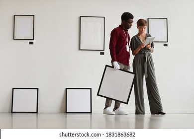 Graphic Full Length Portrait Of Female Art Gallery Manager Using Digital Tablet While Instructing Assistant And Planning Exhibition In Museum, Copy Space