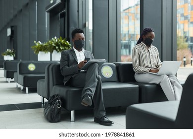 Graphic Full Length Portrait Of Two Business People Wearing Masks While Working In Waiting Lounge At Airport With Social Distancing, Copy Space