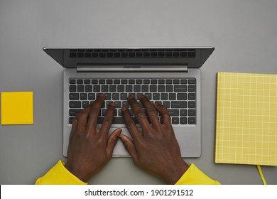 Graphic Gray And Yellow Background Of African-American Male Hands Typing On Laptop Keyboard While Working At Desk, Top Down View, Copy Space