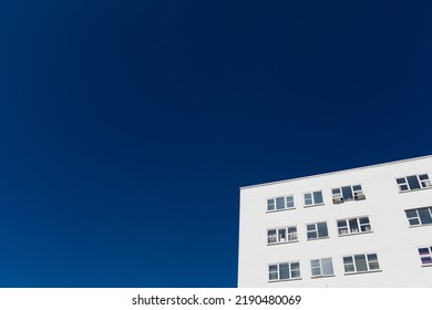 Graphic Section Of A Bright White Modern Residential Apartment Building Against A Clear Deep Blue Sky With Copy Space