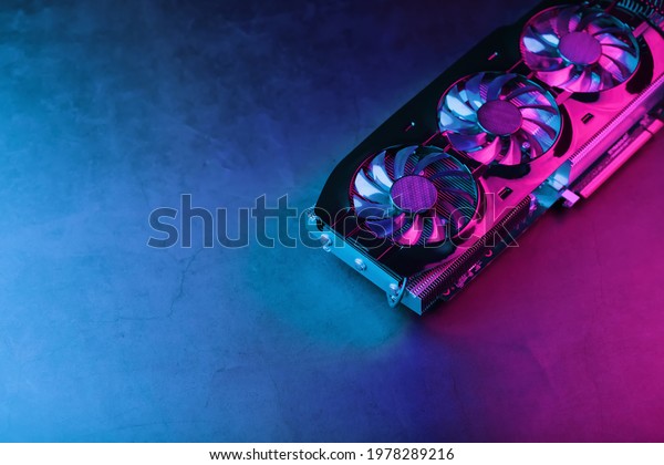 A\
graphics card with a row of fans with a cyanotic purple backlight\
in a futuristic design. Powerful gaming graphics card for video\
games and cryptocurrency mining. Dark key, top\
view