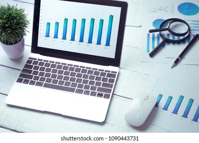 Graphs And Charts Elements On Laptop Computer Screen  And Statistical Performance Of The Company In The Past Year.