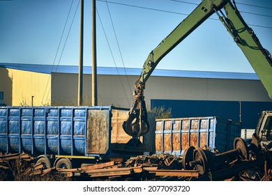 Grapper loader loads truck with scrap metal. Hand of grabber excavator loading recycle metal waste to truck. Clamshell at scrap metal yard - Shutterstock ID 2077093720