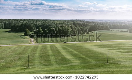 Similar – A tranquil aerial view of a lush golf course fairway, bathed in the warm glow of sunset. Ideal for themes of relaxation, nature, and sports, this image captures the peaceful beauty of the golfing experience.