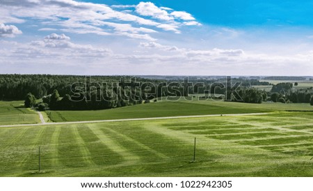 Similar – A tranquil aerial view of a lush golf course fairway, bathed in the warm glow of sunset. Ideal for themes of relaxation, nature, and sports, this image captures the peaceful beauty of the golfing experience.