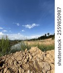 Grass growthing around Sedimentation pond with bright blue cloud background