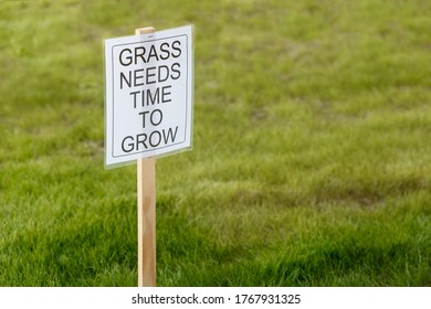 Grass Needs Time To Grow Sign Requesting Others To Stay Off The Freshly Planted Grass