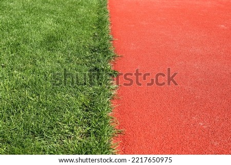 Grass and red ground at a Stadium. Small part of the whole area. Bålsta, Stockholm, Sweden.