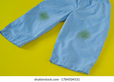 Grass Stains On Pants Isolated On Yellow Background. Daily Life Stain Concept