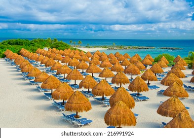 Grass Umbrellas And The Lounges On The Beach Of The Caribbean, Mexican Luxury Resort.