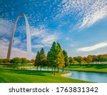 Grass, water and autumn trees surround the Gateway Arch in Saint Louis, Missouri. This is all in the Gateway Arch National Park.