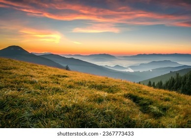 Grassland in the mountains at sunset with sunbeams.
