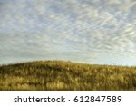 Grassy hilltop in prairie restoration area with pattern of high clouds near sunset in mid October, northern Illinois, USA, for themes of autumn, nature and conservation