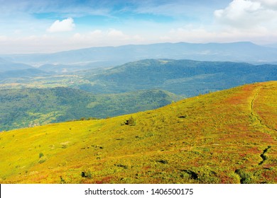 Grassy Slope Of A Hill In Morning Light. Summer Mountain Scenery. Blue Sky With Clouds Above The Distant Ridge And Valley