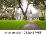 Grassy yard leading to white episcopal church building