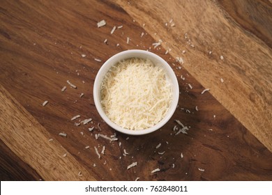 Grated Aged Italian Parmesan Cheese In White Bowl On Table