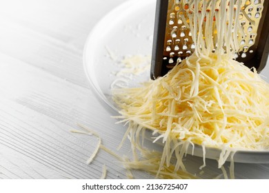 Grated cheese and grater. Concept: Italian cuisine, cheese, restaurant, and food. Copy space.
