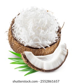 Grated coconut pulp in cracked coconut shell with green leaves and piece of coconut near it isolated on white background.  