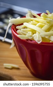 Grated Monterrey Jack Cheese In Red Ceramic Bowl. 