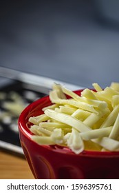 Grated Monterrey Jack Cheese In Red Ceramic Bowl. 