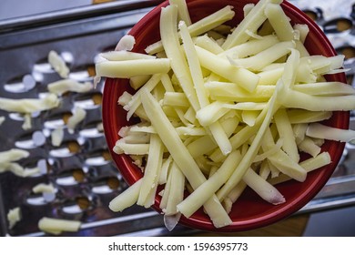 Grated Monterrey Jack Cheese In Red Ceramic Bowl. 