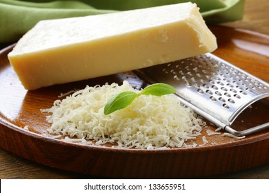 grated parmesan cheese and metal grater on wooden plate - Powered by Shutterstock