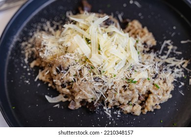 Grated Parmesan Cheese On Top Of Mushroom Risotto On Black Plate. Healthy Vegetarian Menu, Fancy Restaurant Concepts