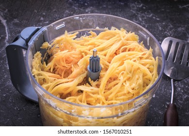 Grated Potato Into A Food Processor. Grated Potato Prepared For Making Potato Pancakes, Draniki, Deruny, Potato Latkes. Grated Raw Potatoes.