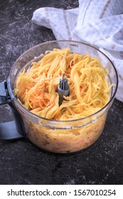 Grated Potato Into A Food Processor. Grated Potato Prepared For Making Potato Pancakes, Draniki, Deruny, Potato Latkes. Grated Raw Potatoes.