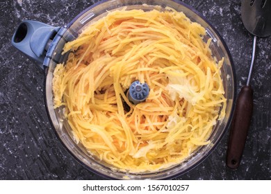 Grated Potato Into A Food Processor. Grated Potato Prepared For Making Potato Pancakes, Draniki, Deruny, Potato Latkes. Grated Raw Potatoes.