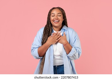 Grateful African American Woman Pressing Hands To Chest Standing Posing With Eyes Closed Over Pink Background. Studio Shot Of Obese Lady Expressing Gratitude. Happiness And Kindness Concept - Shutterstock ID 2207807413