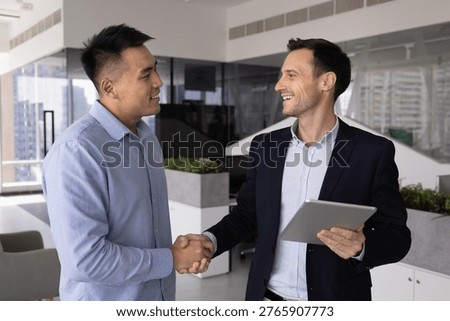 Grateful client shaking hands with consultant manager advisor holding digital tablet in office appreciating help support professional assistance confirming deal agreement built on reliability trust