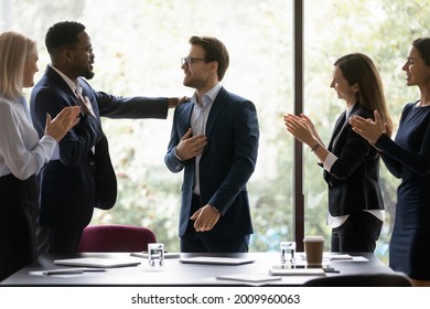 Grateful diverse team expressing recognition, appreciation, acknowledge to leader, clapping hands, touching shoulder, congratulating boss on achieve, good work result, applauding promoted coworker - Powered by Shutterstock